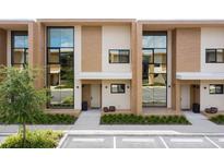 Modern townhouses with large windows and a neutral color palette at 7487 Brooklyn Dr, Kissimmee, FL 34747