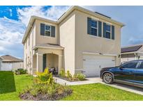 Two-story house with a garage and landscaped lawn at 1839 Wild Rye Way, Kissimmee, FL 34744