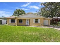 Single story home with light yellow exterior and green lawn at 3247 Shady Willow Dr, Orlando, FL 32808