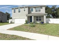 Two-story house with gray siding, white garage door, and landscaped front yard at 1186 August Sky Dr, Deltona, FL 32738