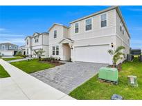 Two-story house with a gray double garage and landscaped yard at 4353 Lana Ave, Davenport, FL 33897