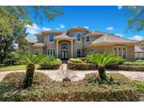 Two-story house with tile roof, landscaping, and a long driveway at 10527 Emerald Chase Dr, Orlando, FL 32836