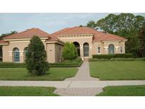 One-story home with tile roof, arched entryway, and landscaped yard at 136 Osprey Hammock Trl, Sanford, FL 32771