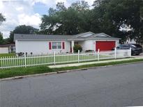 Charming single story home with red garage door and white picket fence at 713 W 2Nd St, Lakeland, FL 33805