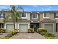 Two-story townhome with two-car garage and lush landscaping at 2663 River Landing Dr, Sanford, FL 32771