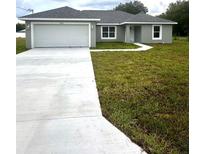 Newly built single story house with a two-car garage and driveway at 12202 Se 87Th Ct, Belleview, FL 34420