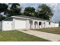 Newly renovated home with a white fence and a spacious driveway at 7609 Rose Ave, Orlando, FL 32810