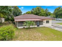 Single-story home with a yard, driveway and street view at 1404 E Alfred St, Tavares, FL 32778