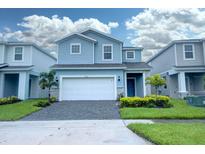 Two-story house with light blue siding and a white garage door at 4063 Lana Ave, Davenport, FL 33897