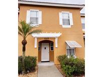 Two story townhome with stucco exterior and walkway at 1107 Park Ridge Cir, Kissimmee, FL 34746