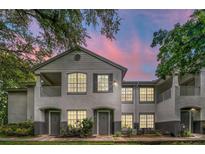 Two-story townhome with light gray exterior, balcony, and landscaping at 4368 S Kirkman Rd # 212, Orlando, FL 32811