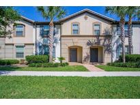Two story townhome with gray siding and lush landscaping at 8924 Adriatico Ln, Kissimmee, FL 34747