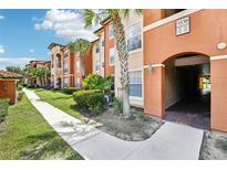 Exterior view of residential building with walkway and landscaping at 5530 Metrowest Blvd # 9-211, Orlando, FL 32811