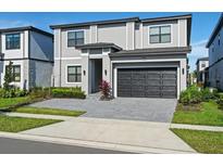 Two-story home with gray exterior, black garage door, and landscaping at 5936 High Seas Dr, Orlando, FL 32821