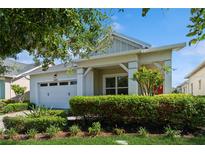 Craftsman style home with white two-car garage and red door at 4909 W Fountainwood Dr, St Cloud, FL 34772