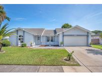 Single-story home with a two-car garage and landscaped yard at 2200 Bay Leaf Dr, Orlando, FL 32837