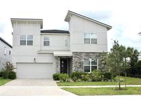Two-story modern home with stone accents and a landscaped front yard at 1864 Caribbean View Ter, Kissimmee, FL 34747