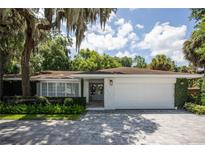 White house with gray paver driveway, landscaping, and a two-car garage at 11130 Park Ave, Windermere, FL 34786