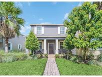 Two-story house with gray exterior, white shutters, and a landscaped front yard at 7642 Fairgrove Ave, Windermere, FL 34786