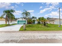 House exterior with teal garage door and palm trees at 647 S Delmonte Ct, Kissimmee, FL 34758