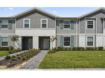 Two-story townhome with gray siding, landscaped lawn, and walkway at 936 Paradise Dr, Davenport, FL 33897