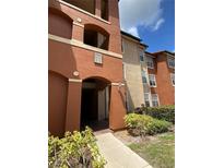 Condo building entrance with address numbers and landscaping at 5578 Metrowest Blvd # 107, Orlando, FL 32811