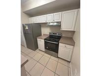 Condo kitchen with stainless steel appliances and light wood cabinets at 5578 Metrowest Blvd # 107, Orlando, FL 32811