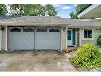 Grey garage with screen door and spacious driveway at 701 Castlewood Dr, Winter Springs, FL 32708