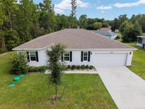 One-story home with two-car garage and landscaped yard at 781 Marion Oaks Trl, Ocala, FL 34473