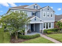 Two-story home with covered front porch and large lawn at 1493 Reflection Cv, Saint Cloud, FL 34771