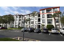 Exterior view of an apartment building with balconies and parking at 4114 Breakview Dr # 406, Orlando, FL 32819