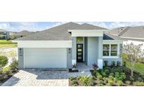 One-story home with gray exterior, two-car garage, and landscaped yard at 815 Liliana Dr, Deland, FL 32724
