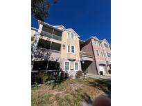 Tan three-story building with balconies and screened porches at 6413 Astor Village Ave # 303, Orlando, FL 32835