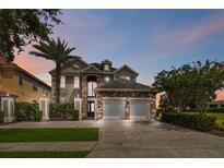 Two-story house with stone and stucco exterior, three-car garage, and landscaping at 1257 Radiant St, Reunion, FL 34747