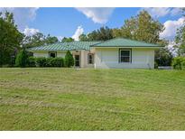 Single-story home with green metal roof and lush lawn at 2620 Osceola Bluff Ln, Geneva, FL 32732