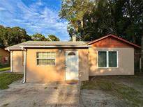 Tan ranch style house with orange accents and a white door at 813 S Florida Ave, Deland, FL 32720
