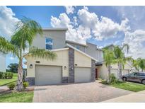 Modern three-unit townhome with attached garages at 875 Ocean Course Ave, Davenport, FL 33896