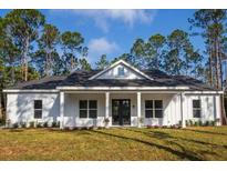 White farmhouse exterior with a covered porch and landscaped yard at 6979 Big Bend Dr, St Cloud, FL 34771