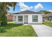 Charming white house with a gray roof, covered porch, and a concrete driveway at 2236 Sipes Ave, Sanford, FL 32771