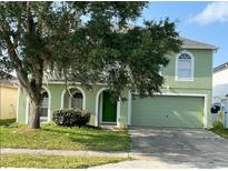 Two-story house with green exterior, arched entryway, and a two-car garage at 366 Fairfield Dr, Sanford, FL 32771