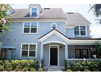 Two-story light blue home with a black door and white trim at 3478 Westchester Square Blvd # 202, Orlando, FL 32835