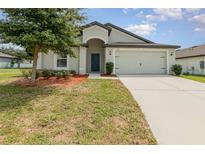 Single-story home with attached garage and manicured lawn at 1680 Gopher Tree St, Mascotte, FL 34753