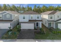Two-story house with gray and white exterior and two-car garage at 4424 Kaipo Rd, Davenport, FL 33897