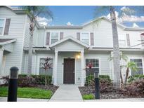 Two-story home with neutral siding, brown door, and landscaping at 3211 Gold Ln, Kissimmee, FL 34747