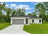 New construction home with gray garage door at 556 Marion Oaks Pass, Ocala, FL 34473