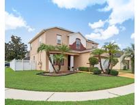 Two-story house with landscaping and palm trees at 11932 Old Glory Dr, Orlando, FL 32837