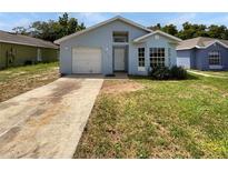 Single-story home with light blue siding, a garage, and a small front yard at 6516 Viewpoint Ct, Orlando, FL 32810
