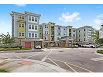 Modern apartment building with parking and landscaping at 7573 Laureate Blvd # 1301, Orlando, FL 32827