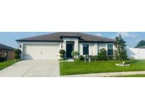 Single-Gathering home with a two-car garage and landscaped yard at 1908 Piedmont Ct, Mascotte, FL 34753