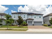 Two-story house with gray siding, solar panels, and two-car garage at 8324 Ludington Cir, Orlando, FL 32836